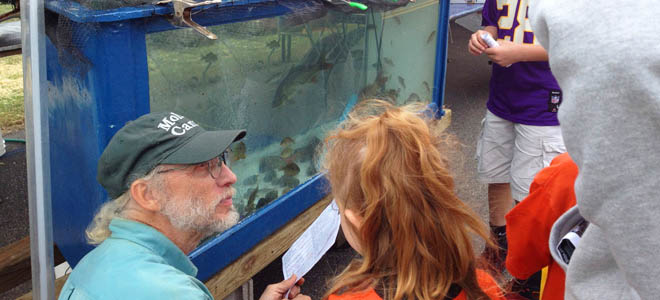 RU biologist Bernie talking to children in front of RU aquarium 