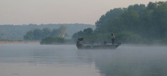 fisherman in early morning fog on john boat, Great Miami River near Shawnee Lookout